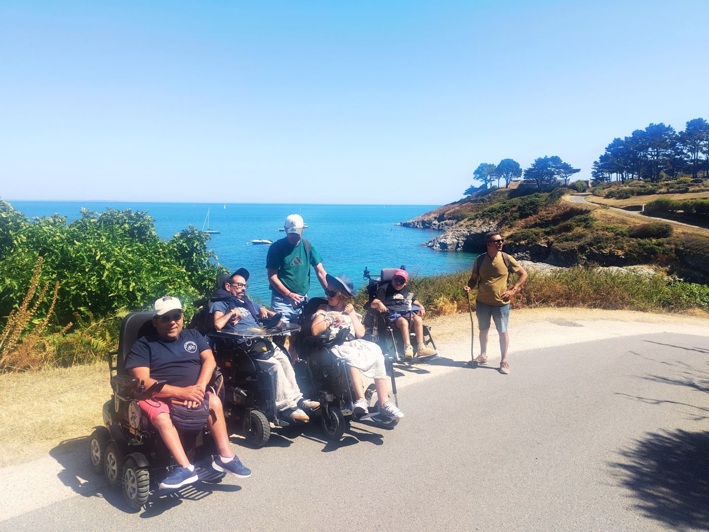 Participants en fauteuil et bénévoles lors d'une sortie au bord de la mer